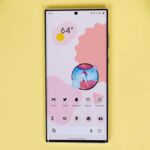 Google Pixel 10a encostado em uma árvore verde