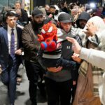 Uma suposta noiva do ISIS é escoltada sob custódia por oficiais federais.