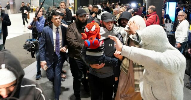 Uma suposta noiva do ISIS é escoltada sob custódia por oficiais federais.