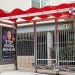 Bus stop shelter with red canopy and ad for Artisan AI reading "Stop Hiring Humans" and "For Work They Hate" on city sidewalk, San Francisco, California, September 30, 2025. (Photo by Smith Collection/Gado/Getty Images)