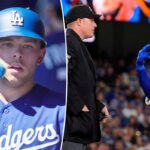 Dalton Rushing em seu uniforme azul dos Dodgers e capacete de batedor cumprimenta seus companheiros de equipe no banco de reservas.