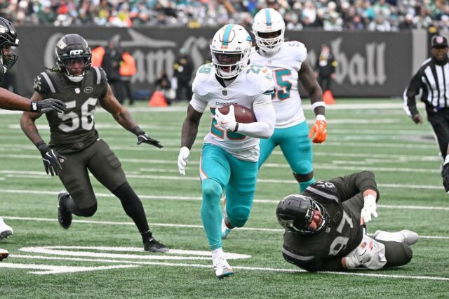 O running back dos Dolphins, De'Von Achane (28), corre a bola para um touchdown durante o primeiro quarto no jogo Jets e Miami Dolphins em East Rutherford, NJ. 