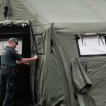 Um membro da Guardia Civil termina de montar uma tenda num ponto de recepção esperado para passageiros do MV Hondius no Porto de Granadilla.