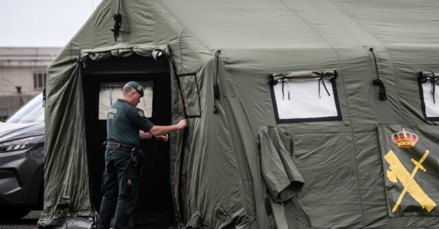 Detalhes do plano de evacuação do navio de cruzeiro contra Um membro da Guardia Civil termina de montar uma tenda num ponto de recepção esperado para passageiros do MV Hondius no Porto de Granadilla.
