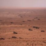 Forças militares dos EUA e do Marrocos conduzindo um exercício militar no deserto.
