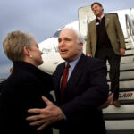 Sonhar. John McCain estende a mão para sua esposa Cindy, acompanhado pelo filho, Doug McCain, quando o então candidato presidencial republicano chega a Syracuse, Nova York, em 4 de março de 2000.