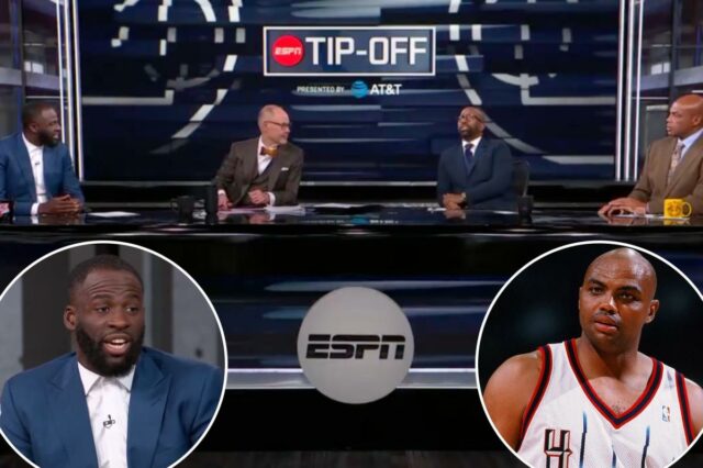 Draymond Green falando em um evento, vestindo um terno azul e uma camisa branca com microfone acoplado.
