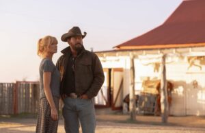 ‘Dutton Ranch’: Por que Cole Hauser e Kelly Reilly retornaram aos seus personagens de ‘Yellowstone’ Uma mulher com uma camisa branca de botão e um chapéu de cowboy preto cavalga um cavalo palomino claro sob a luz dourada do fim da tarde. Sua expressão é resoluta enquanto ela olha para longe, a luz do sol inundando a moldura por trás.