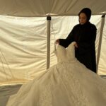 O casal, Mohammad Ahliwat e Saja Al-Masri, que se casarão em poucos dias, se prepara para o casamento dentro de uma tenda em um campo de deslocados (Al Jazeera)