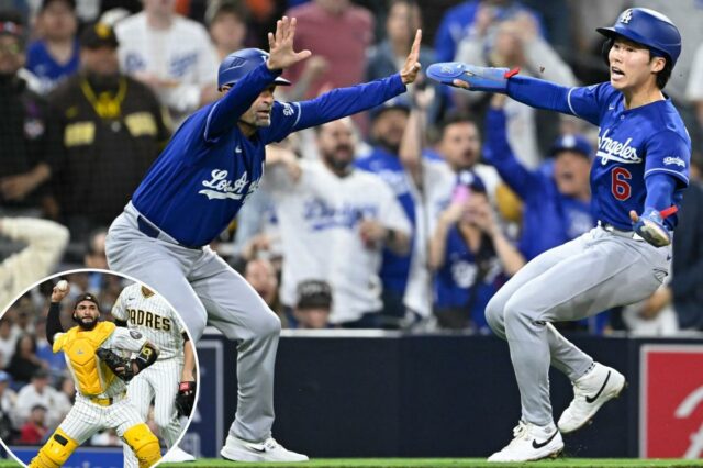 O apanhador do San Diego Padres, Austin Nola, lança para uma base enquanto o arremessador Joe Musgrove observa.