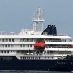 Profissionais de saúde com equipamento de proteção evacuam pacientes do navio de cruzeiro MV Hondius num porto da Praia, Cabo Verde, quarta-feira, 6 de maio de 2026. (AP Photo/Misper Apawu)