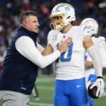 FOXBOROUGH, MASSACHUSETTS - JANUARY 11: Head coach Mike Vrabel of the New England Patriots talks with Justin Herbert #10 of the Los Angeles Chargers prior to an AFC wild card playoff football game at Gillette Stadium on January 11, 2026 in Foxborough, Massachusetts. (Photo by Kathryn Riley/Getty Images)