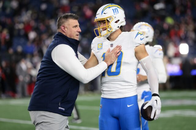 FOXBOROUGH, MASSACHUSETTS - JANUARY 11: Head coach Mike Vrabel of the New England Patriots talks with Justin Herbert #10 of the Los Angeles Chargers prior to an AFC wild card playoff football game at Gillette Stadium on January 11, 2026 in Foxborough, Massachusetts. (Photo by Kathryn Riley/Getty Images)
