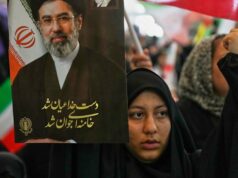 Estas são as cinco principais questões a serem resolvidas no acordo EUA-Irã Uma mulher iraniana carrega um retrato do líder supremo Mojtaba Khamenei. Em vez de ser derrubado, o regime parece ter consolidado ainda mais a sua posição após o ataque EUA-Israel.