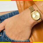 Colagem de três relógios Nixon, incluindo dois relógios de ouro com mostrador preto e dourado e um relógio prateado com mostrador preto.