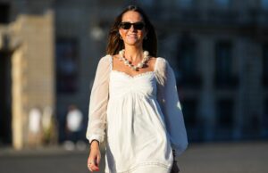 Estes vestidos de primavera lisonjeiros escondem tops de muffin sem modeladores, a partir de US $ 15 Diane Batoukina usa vestido midi de seda branca com estampa de listras azuis e marinho, mangas curtas e gola pontuda da Sandro. Um lenço de seda Sandro combinando está amarrado frouxamente no decote. Uma mini bolsa branca com alça de corrente e detalhes dourados da Chanel é usada na transversal. O calçado consiste em sandálias brancas de salto aberto da Aeyde. Os óculos de sol quadrados Dior com lentes gradientes escuras completam o visual. Cabelo castanho longo e liso é penteado com uma parte central. Os lábios ficam sutilmente coloridos e a pele parece lisa e uniforme. Foto de corpo inteiro, durante uma sessão de fotos de moda de rua, em 28 de abril de 2025 em Paris, França.