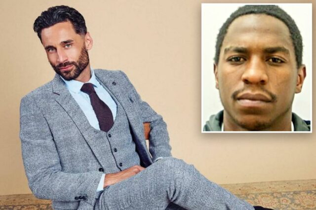 Luke Harden em um terno de três peças estampado azul claro, gravata escura, camisa azul claro e sapatos marrons, sentado em uma cadeira.