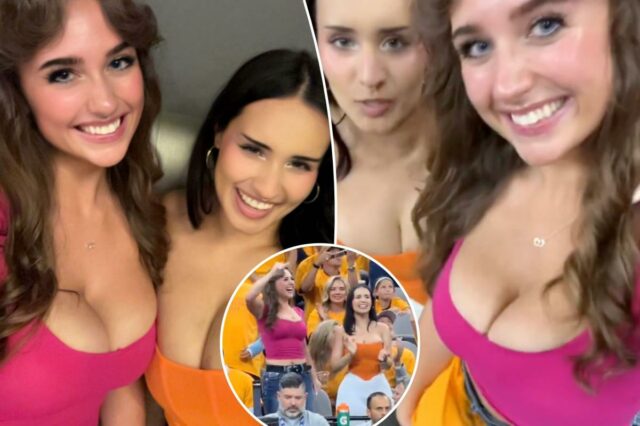 Duas mulheres sorridentes, uma com blusa rosa e outra com blusa laranja, posam para uma foto.