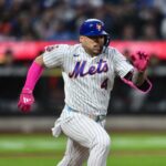 O apanhador do New York Mets, Francisco Alvarez (4), eliminou o homem da terceira base do Detroit Tigers, Colt Keith (33), em uma jogada na base, encerrando a quinta entrada.