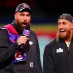 LAS VEGAS, NEVADA - FEBRUARY 05: Travis Kelce of the Kansas City Chiefs (L) and George Kittle of the San Francisco 49ers stand on stage during Super Bowl LVIII Opening Night at Allegiant Stadium on February 05, 2024 in Las Vegas, Nevada. (Photo by Chris Unger/Getty Images)
