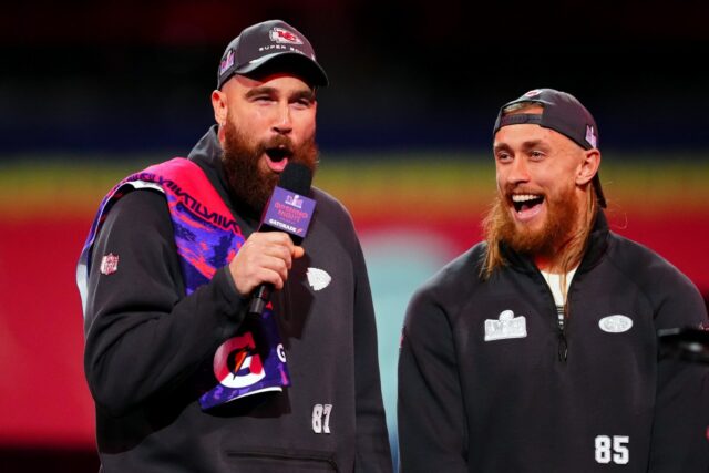 LAS VEGAS, NEVADA - FEBRUARY 05: Travis Kelce of the Kansas City Chiefs (L) and George Kittle of the San Francisco 49ers stand on stage during Super Bowl LVIII Opening Night at Allegiant Stadium on February 05, 2024 in Las Vegas, Nevada. (Photo by Chris Unger/Getty Images)