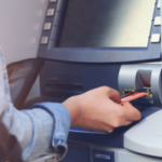 Pessoa inserindo cartão bancário em caixa eletrônico durante transação de retirada de dinheiro em caixa eletrônico estilo Citizens Bank. Gerente de banco da Pensilvânia preso após roubar fundos para sustentar o hábito de jogo