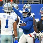 O tackle defensivo do Giants, Elijah Chatman (94), reage durante um jogo de futebol.