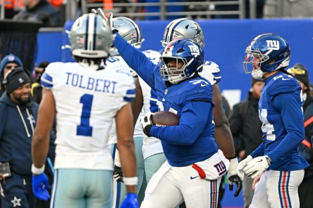 O tackle defensivo do Giants, Elijah Chatman (94), reage durante um jogo de futebol.