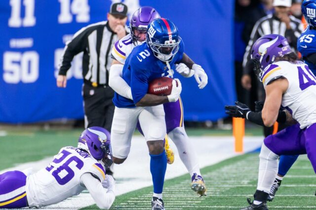 O jogador do New York Giants, Deonte Banks, corre a bola enquanto o jogador do Minnesota Vikings, Ivan Pace Jr., o aborda.