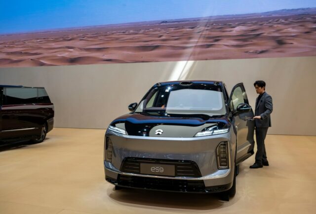 Grande aposta chinesa compensa na guerra do Irã A sales person opens the door of an ES9 electric SUV made by Chinese automaker NIO at the Beijing International Auto Exhibition on April 25, 2026.