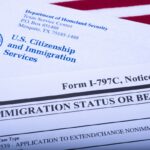 An official USCIS envelope is seen next to Form I - 797C (Notice of action, immigration status) and an American flag on September 20, 2018, in Washington, DC.