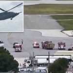 Um helicóptero cinza escuro voando contra um céu nublado.