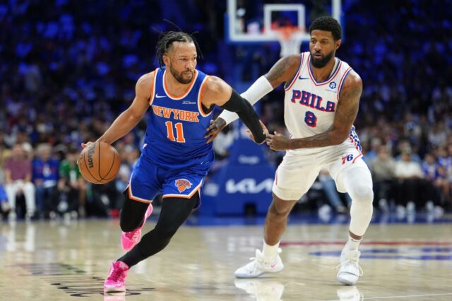 O armador do Knicks, Jalen Brunson (11), enfrenta o atacante do 76ers Paul George (8) durante o jogo 4 em 10 de maio de 2026.