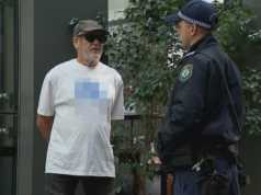 Homem vestindo camisa com suástica fora da audiência da comissão real foi transferido pela polícia Um homem recebeu ordens da polícia para seguir em frente depois de usar uma camisa com uma suástica do lado de fora do prédio onde a comissão real está sendo realizada.
