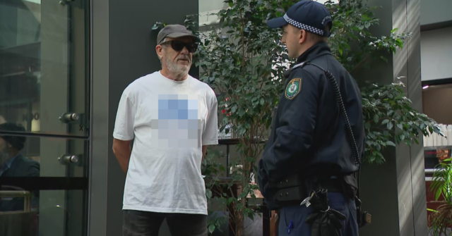 Um homem recebeu ordens da polícia para seguir em frente depois de usar uma camisa com uma suástica do lado de fora do prédio onde a comissão real está sendo realizada. 