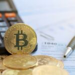 Ilustração de um smartphone exibindo um aplicativo de negociação Bitcoin com opções de compra/venda e uma tabela de preços, cercado por pilhas de moedas Bitcoin douradas.