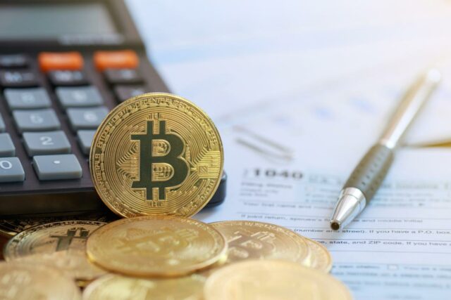 Ilustração de um smartphone exibindo um aplicativo de negociação Bitcoin com opções de compra/venda e uma tabela de preços, cercado por pilhas de moedas Bitcoin douradas.