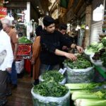 Pessoas caminham em um mercado local em Teerã