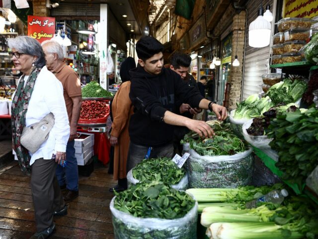 Inflação alimentar atinge famílias no Irão, atingido pela guerra Pessoas caminham em um mercado local em Teerã