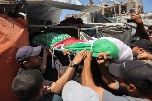 Palestinos carregando o corpo de uma pessoa morta em ataques aéreos israelenses para um funeral na Cidade de Gaza.