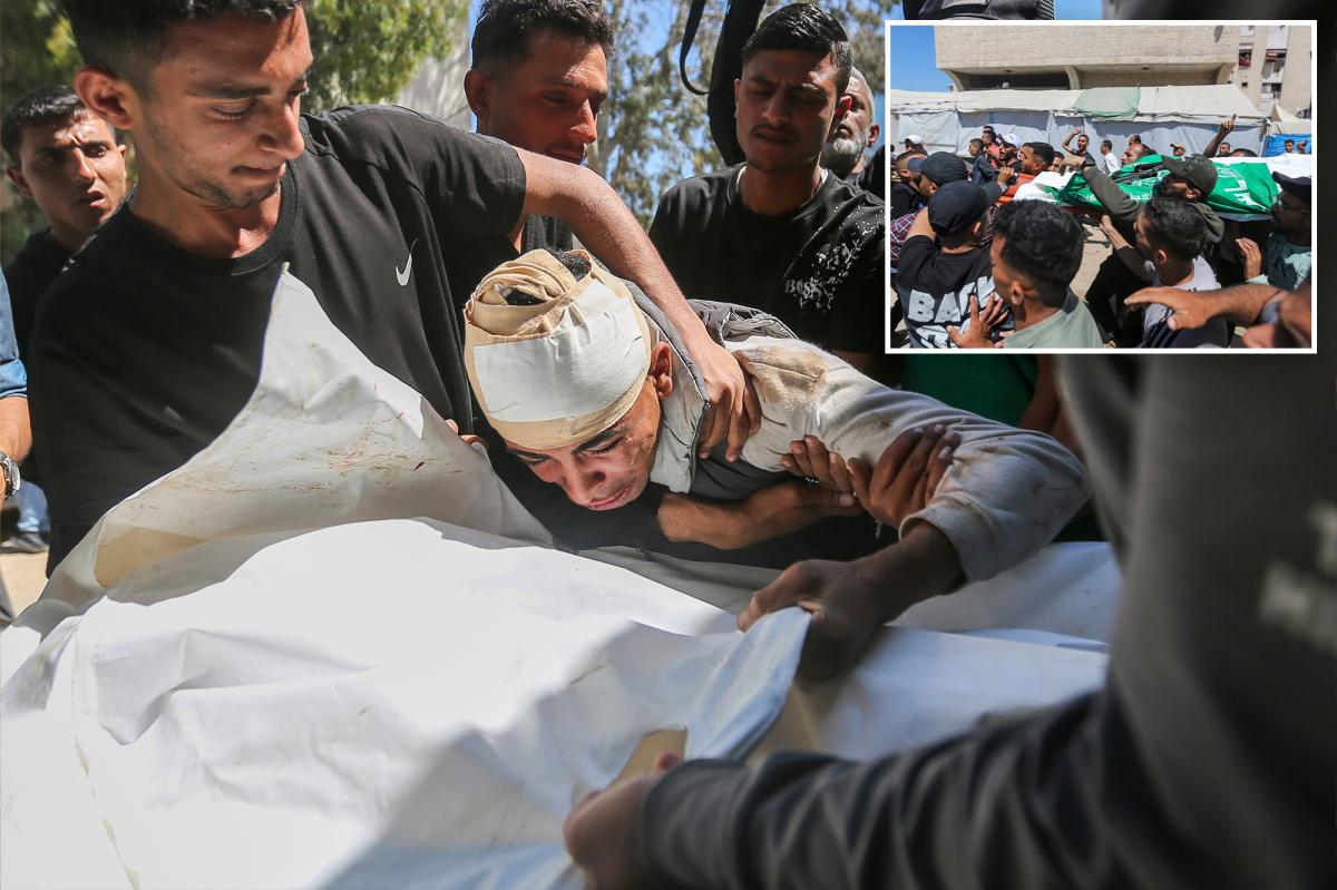 Enlutados carregando o corpo de Imad Aslim envolto em pano branco para seu funeral.