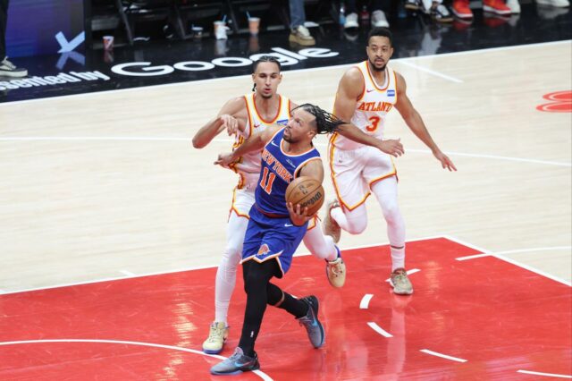 O armador do New York Knicks, Jalen Brunson (11), vai até a cesta contra dois jogadores do Atlanta Hawks.