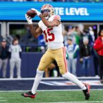 O jogador do San Francisco 49ers, Jauan Jennings, pegando uma bola de futebol.