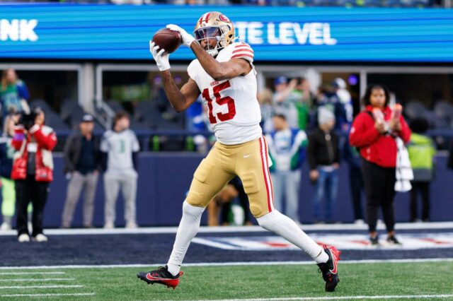 O jogador do San Francisco 49ers, Jauan Jennings, pegando uma bola de futebol.
