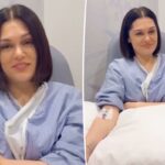 Jessie J com uma intravenosa no braço e vestindo uma bata de hospital, anunciando que está livre do câncer.