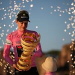 O primeiro colocado, o dinamarquês Jonas Vingegaard, segura o troféu enquanto comemora no pódio no final da corrida de ciclismo Giro d'Italia em Roma, domingo, 31 de maio de 2026. (AP Photo / Andrew Medichini)