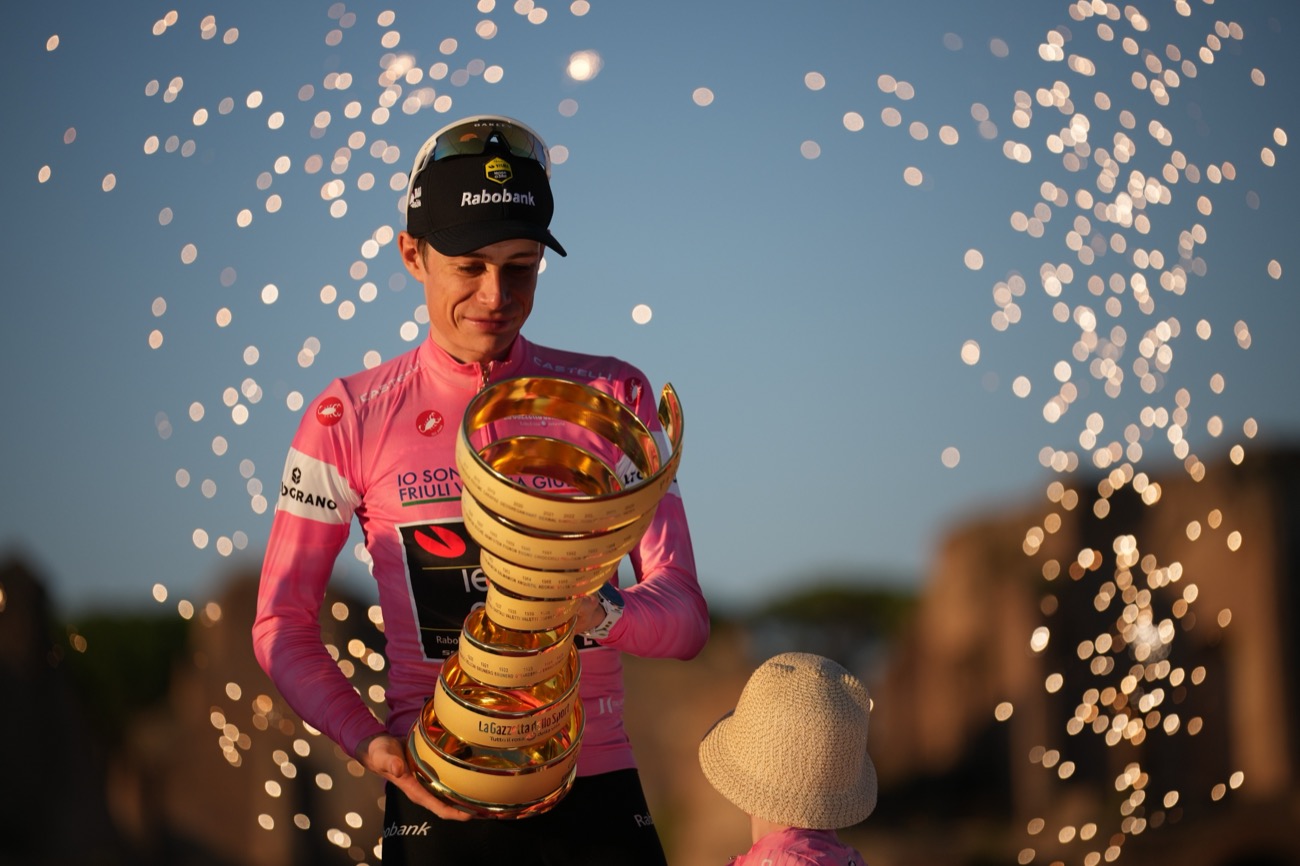 O primeiro colocado, o dinamarquês Jonas Vingegaard, segura o troféu enquanto comemora no pódio no final da corrida de ciclismo Giro d'Italia em Roma, domingo, 31 de maio de 2026. (AP Photo / Andrew Medichini)