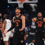 Josh Hart discutindo com um árbitro durante um jogo de basquete.