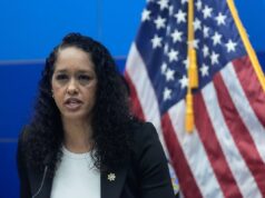 Juízes fora de controle levam a crimes fora de controle Brooke Jenkins falando em um pódio com uma bandeira americana atrás dela.