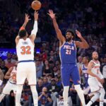 O pivô do New York Knicks, Karl-Anthony Towns # 32, lança um chute sobre o pivô do Philadelphia 76ers, Joel Embiid # 21, no primeiro quarto de um jogo dos playoffs da NBA.